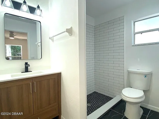 a bathroom with a toilet sink vanity and mirror