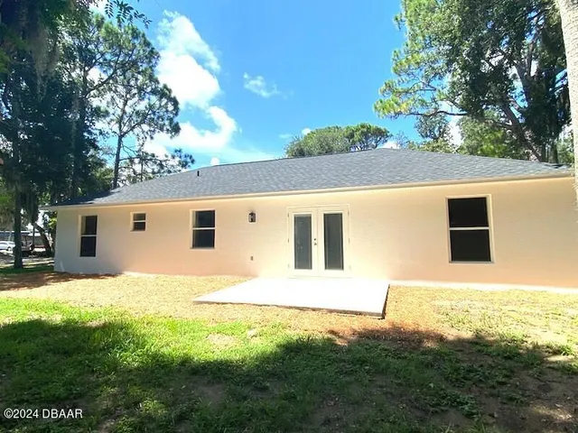 a backyard of a house with table and chairs