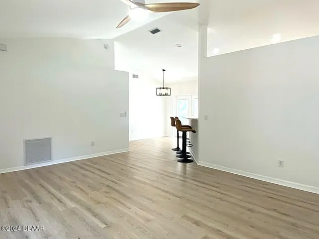 a view of a room with wooden floor and white walls