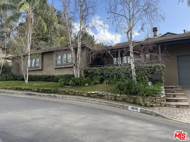 a view of a house with a yard and large tree