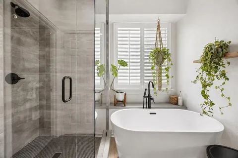 a white bath tub sitting in a bathroom next to a window