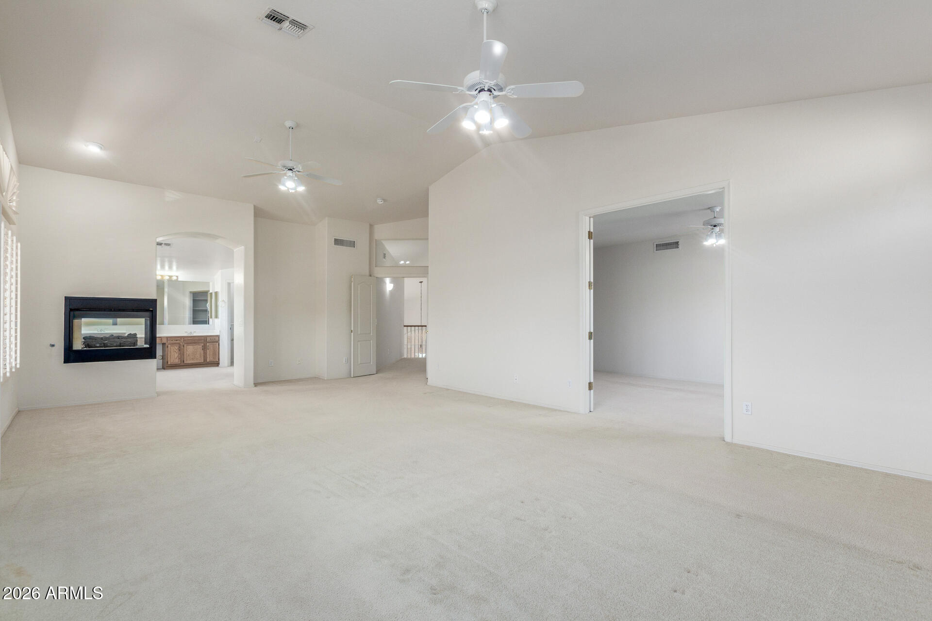 3430 North Mountain Ridge, Unit 13 Mesa, AZ 85207 - Photo 50 of 115 an empty room with a fireplace and a ceiling fan