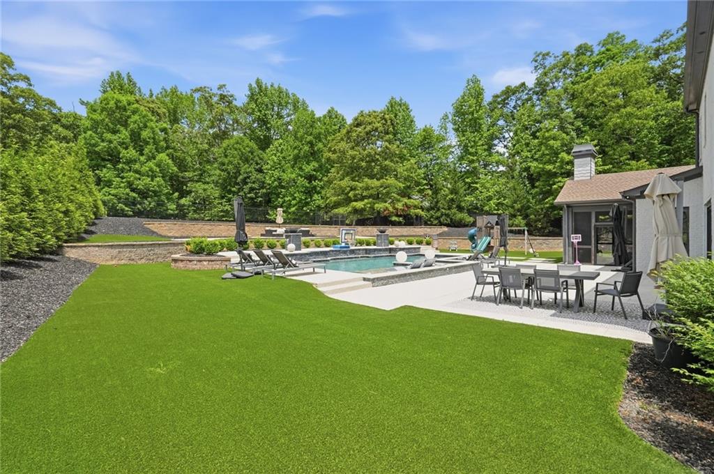 3020 Wallace Road Buford, GA 30519 - Photo 52 of 66 a view of a patio with table and chairs potted plants and large tree