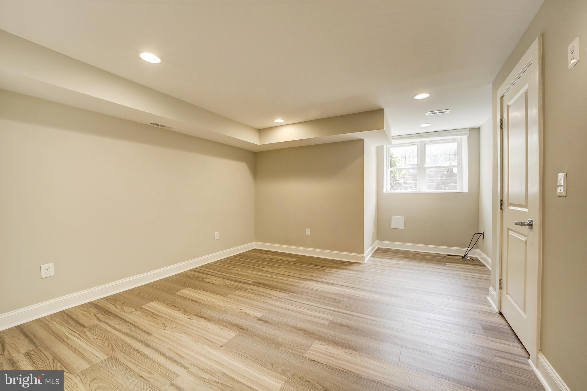1926 1st Street Northwest, Unit 1 Washington, DC 20001 - Photo 24 of 37 an empty room with wooden floor and windows
