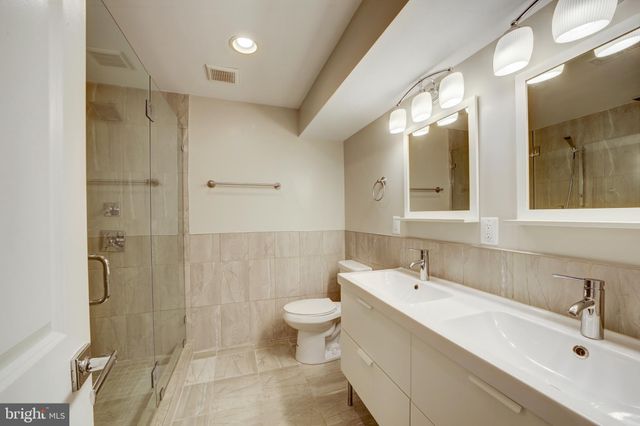 a bathroom with a double vanity sink toilet and shower