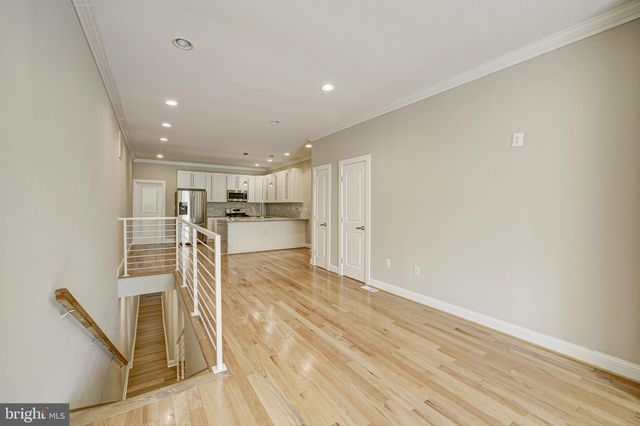 a view of a kitchen with wooden floor and a window