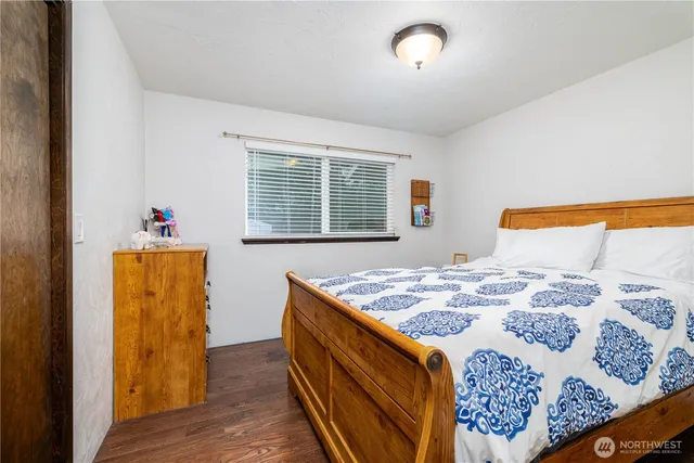 a bedroom with a bed and a dresser next to a window
