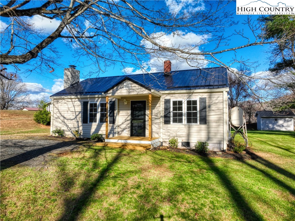 a view of a house with a yard patio and a fire pit