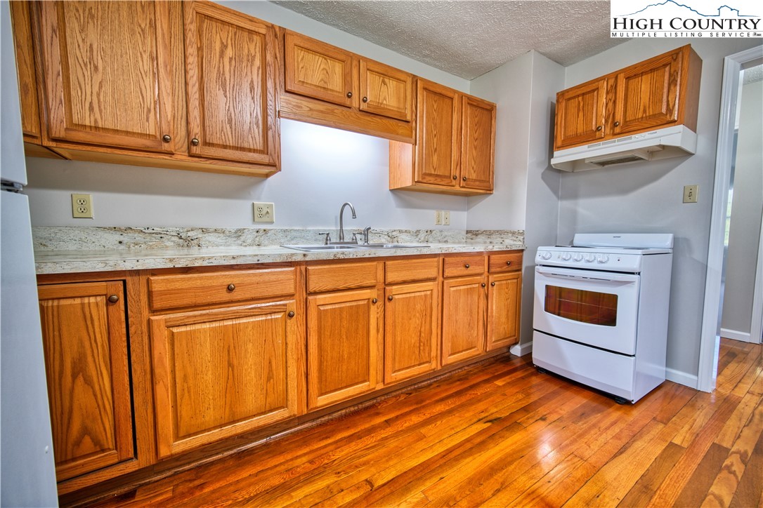 494 Frank Edwards Road West Jefferson, NC 28694 - Photo 9 of 27 a kitchen with granite countertop wooden cabinets stainless steel appliances and a sink
