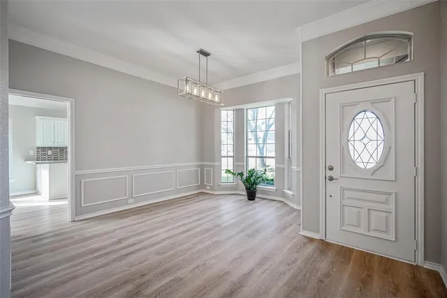 an empty room with wooden floor cabinet and door