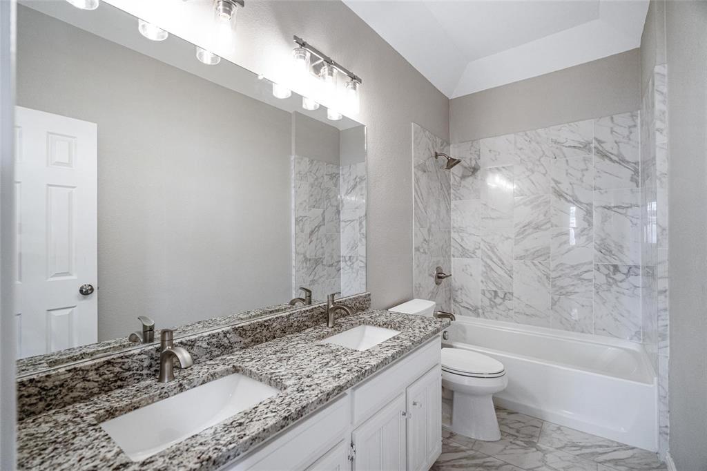 1006 Merribrook Lane Allen, TX 75002 - Photo 24 of 29 a bathroom with a granite countertop sink a mirror and a bathtub
