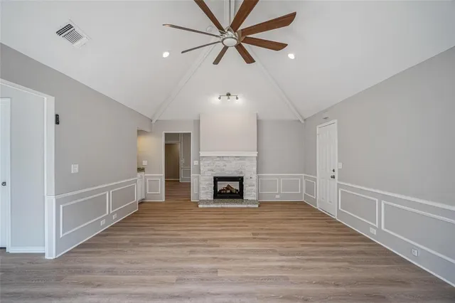 a view of a livingroom with a fireplace a ceiling fan and brick wall