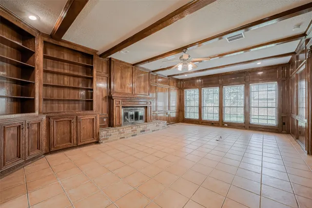 a view of an empty room with a fireplace and a window