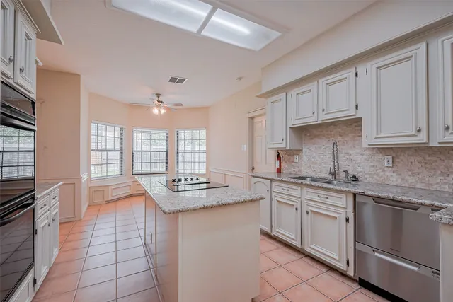 a kitchen with stainless steel appliances granite countertop a sink stove and cabinets