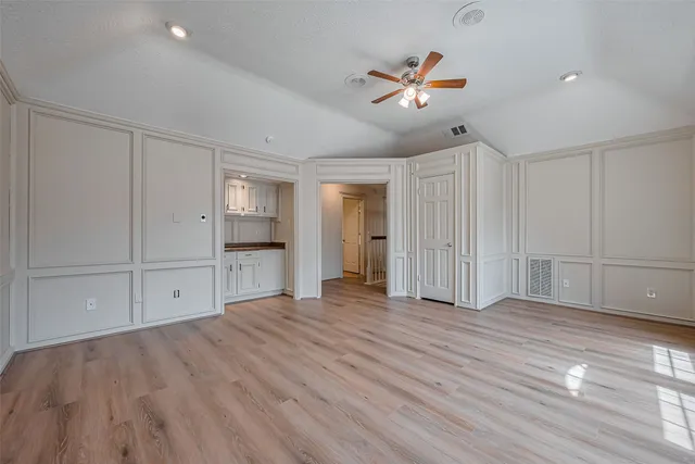 a view of empty room with wooden floor and ceiling fan