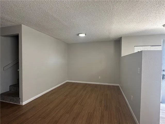 a kitchen with granite countertop cabinets stainless steel appliances and a wooden floor