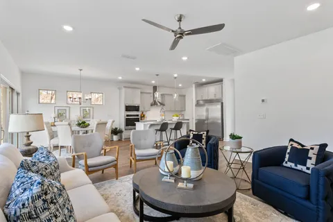 a living room with furniture and a dining table with kitchen view