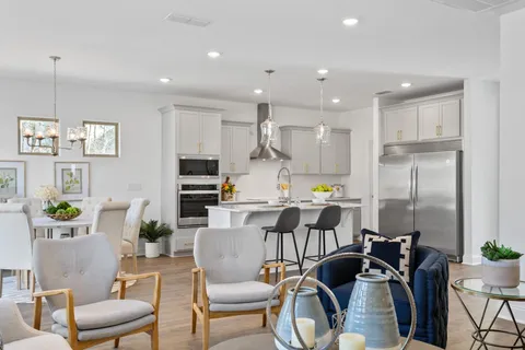 a view of a dining room with furniture a kitchen and chandelier