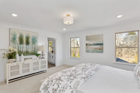 a large white bathroom with a granite countertop shower a sink and a large mirror