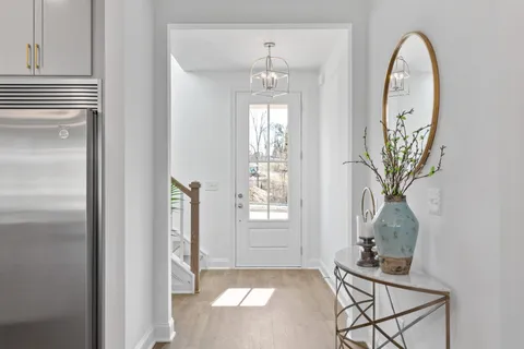 a view of a livingroom with wooden floor and a chandelier