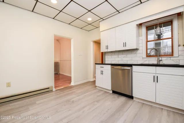 a kitchen with granite countertop white cabinets and white appliances