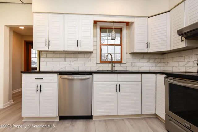 a kitchen with granite countertop white cabinets and white appliances