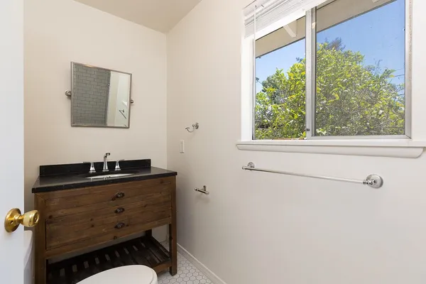a bathroom with a sink a mirror and a window