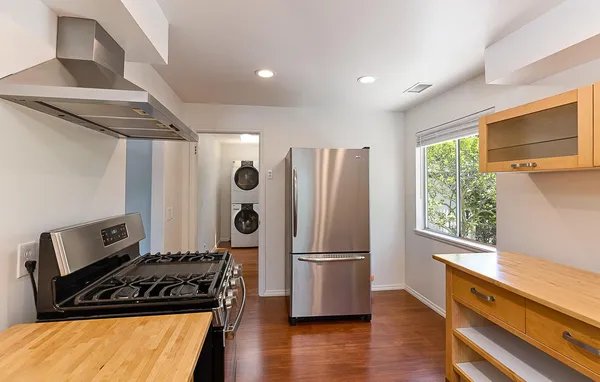 a kitchen with wooden floor and stainless steel appliances