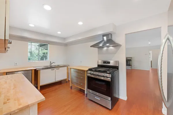 a kitchen with stainless steel appliances a stove a sink and a refrigerator