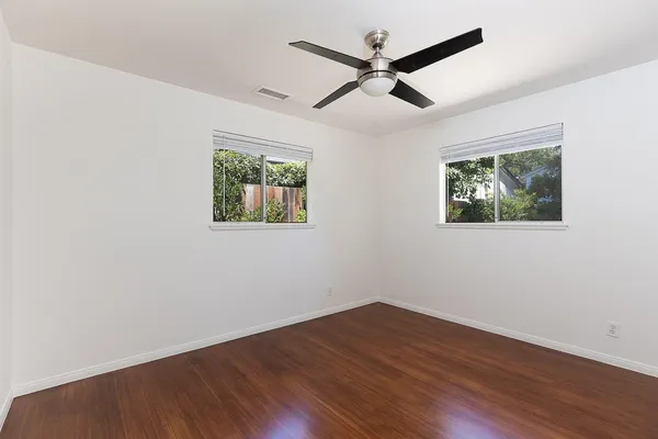 a view of empty room with wooden floor