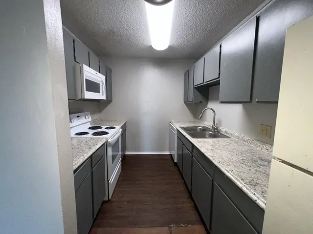a kitchen with granite countertop cabinets stainless steel appliances and a sink