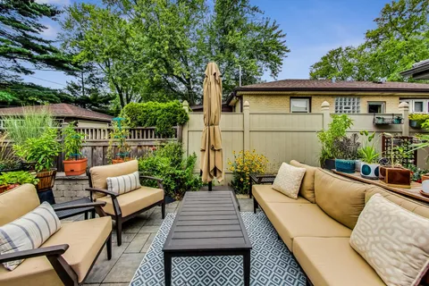 a view of backyard with seating space and potted plants