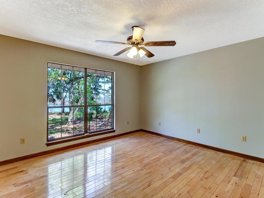 97584 Pirates Point Road Yulee, FL 32097 - Photo 24 of 35 an empty room with wooden floor fan and windows
