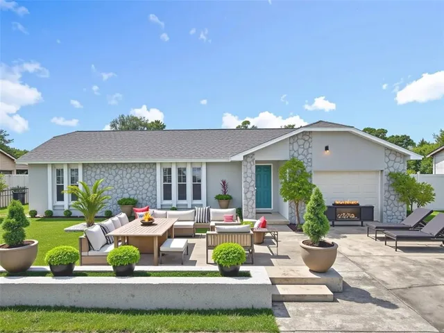 a front view of a house with garden and outdoor seating