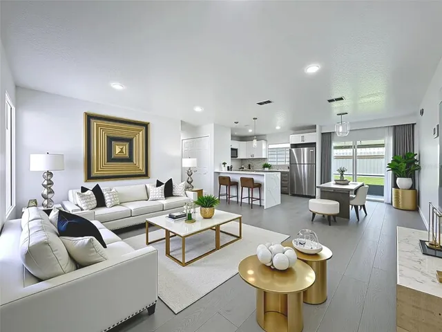 a living room with furniture kitchen view and a wooden floor