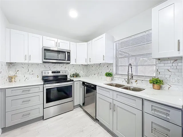 a kitchen with a sink a stove and cabinets