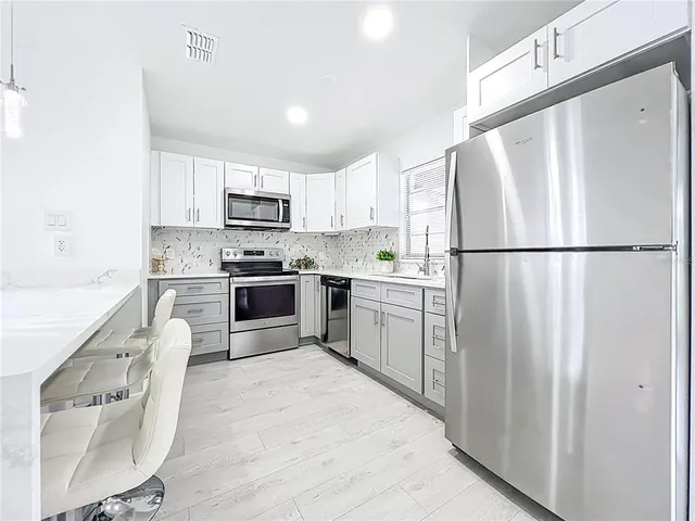 a kitchen with white cabinets and white stainless steel appliances
