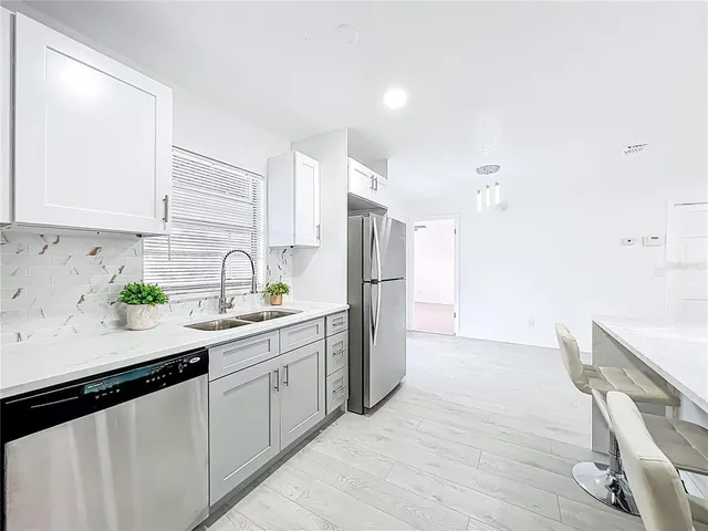 a kitchen with a sink a refrigerator and cabinets