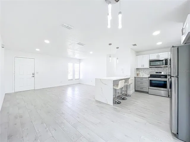 a kitchen with kitchen island white cabinets and stainless steel appliances