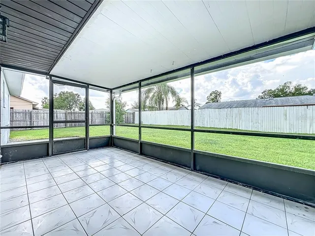 a view of a yard with porch and wooden fence