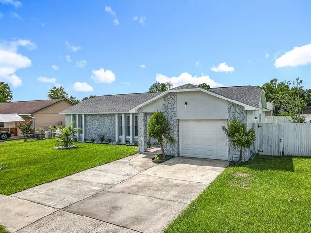 a view of a house with a yard and sitting area