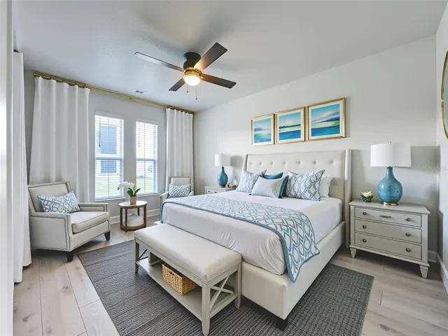 a bedroom with a large bed couch and windows