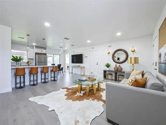an living room with lots of furniture and view of kitchen