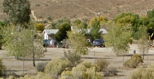a view of a yard with plants and brick wall