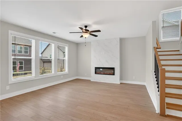 a view of an empty room with a window and a kitchen