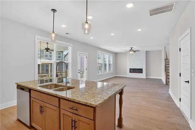 a kitchen with kitchen island granite countertop a large center island a sink stainless steel appliances and cabinets