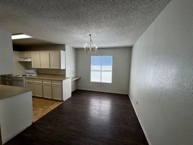 a kitchen with kitchen island granite countertop a sink cabinets and stainless steel appliances