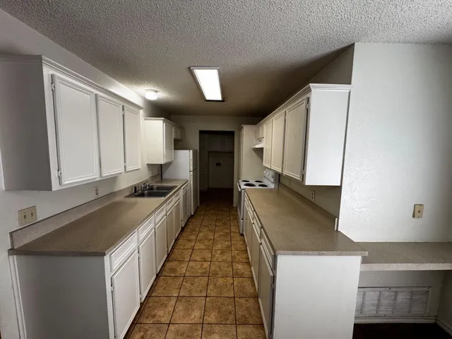 a kitchen with granite countertop a sink and a stove top oven