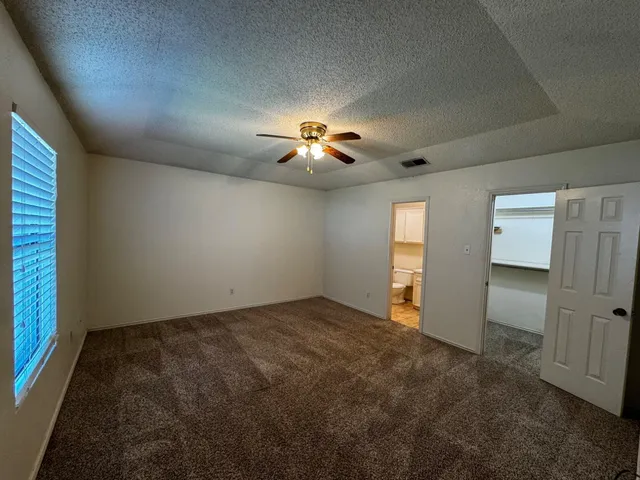 an empty room with closet and windows