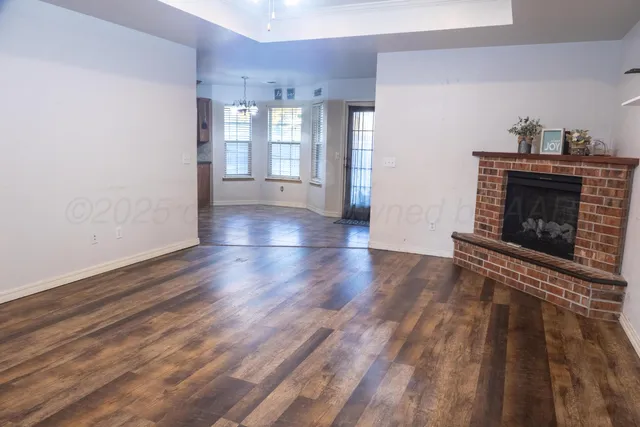 a view of a livingroom with wooden floor and a fireplace
